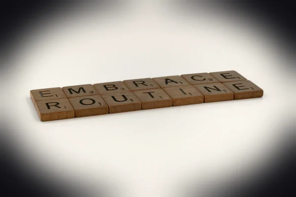 a scrabble tile spelling out the word embrace routine