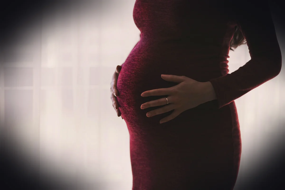 pregnant woman wearing red long-sleeved dress