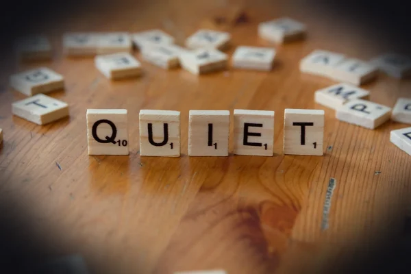 The word quiet spelled with wooden blocks on a table
