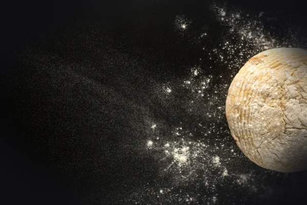 dough on black surface with flour