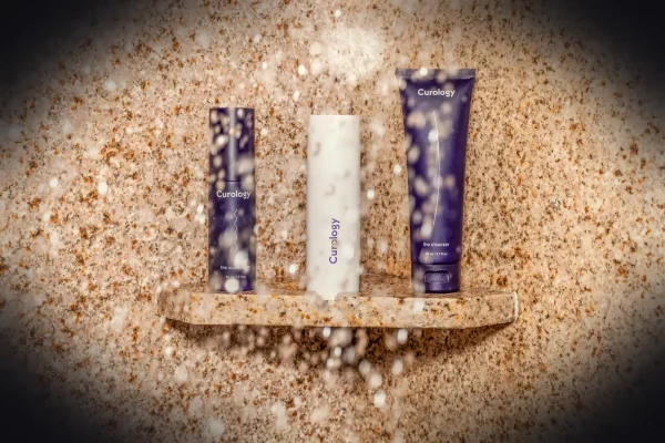 three assorted toiletries on brown shelf