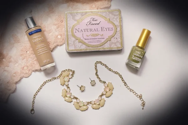 a white table topped with cosmetics and a necklace