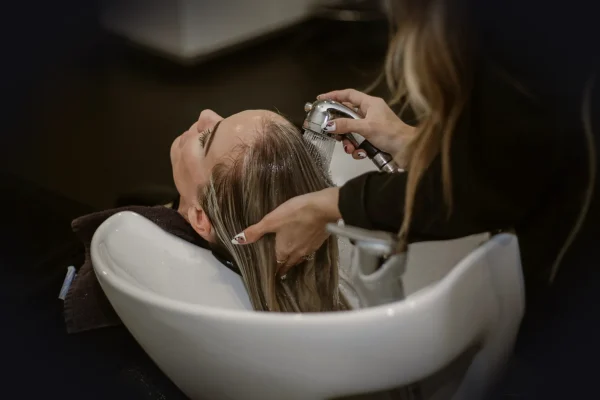 a woman getting her hair cut by a hair stylist