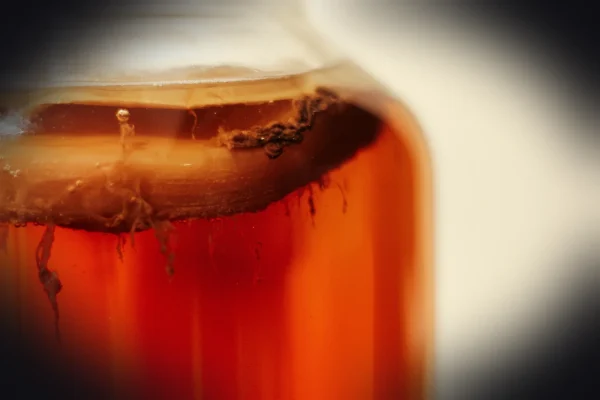 clear glass jar with brown liquid