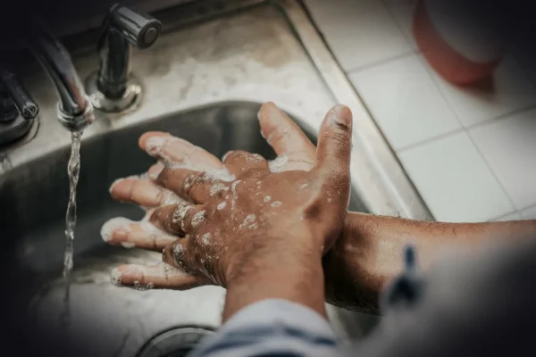 person in white shirt washing hands