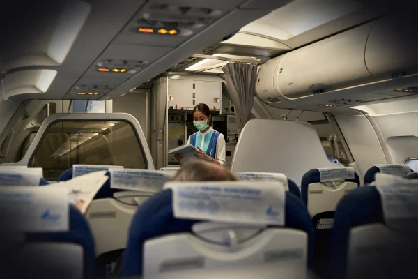 a woman in a face mask sitting on an airplane