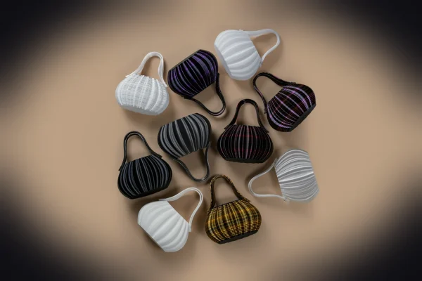 Collection of small, colorful, pleated handbags arranged on a surface.