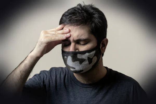 man in black crew neck shirt covering his face with black and white textile