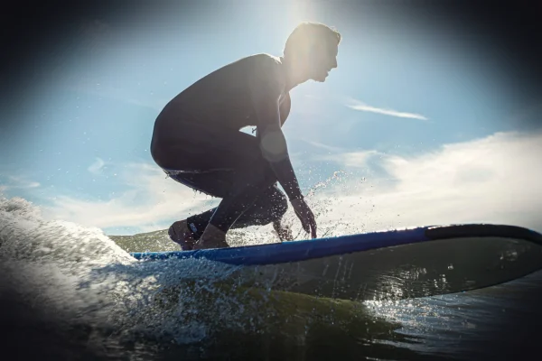 man in black wetsuit surfing on water during daytime