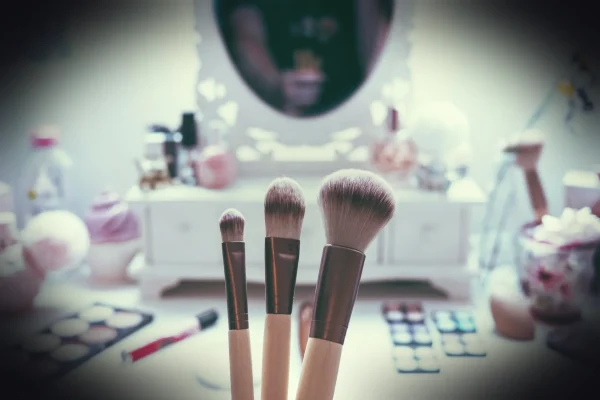 macro shot of three brown makeup brushes