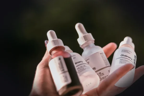 person holding white and black labeled bottles