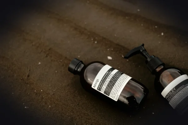 two bottles of lotion sitting on the ground