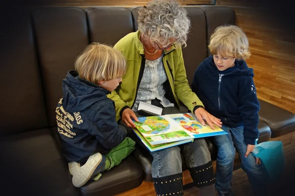to read aloud, grandmother, grandchild, attentively, language development, library, read, book, child, guys, family, chi