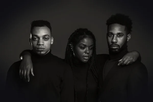 grayscale photo of woman standing between two men