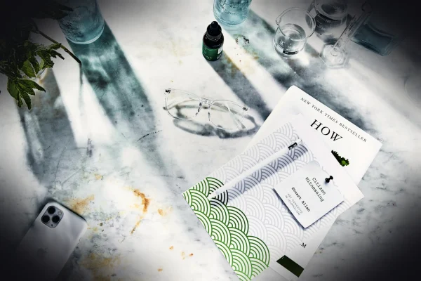 white paper document beside eyeglasses and drinking glass
