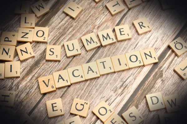 scrabble tiles spelling vacation on a wooden surface