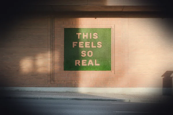 a green sign that reads this feels so real