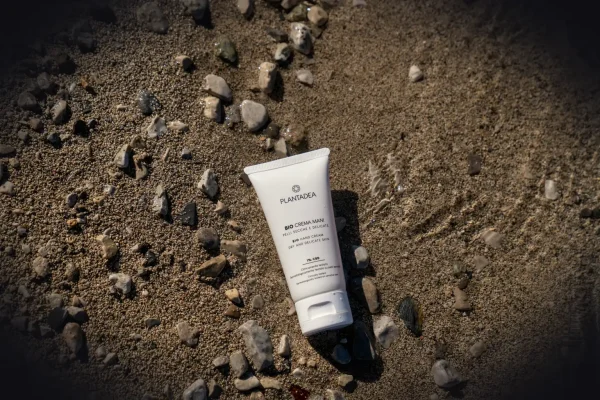 A tube of sunscreen sitting on the ground