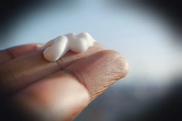 A hand holding a small piece of marshmallow